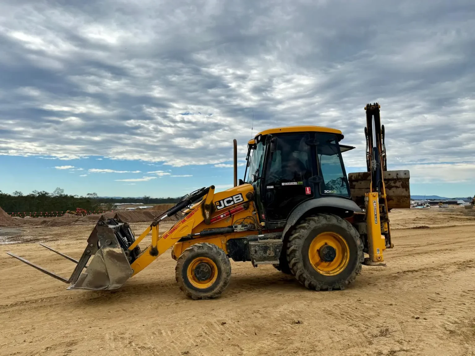 JCB backhoe available for hire on a civil job site near Ipswich, provided by ACE Rental Queensland.