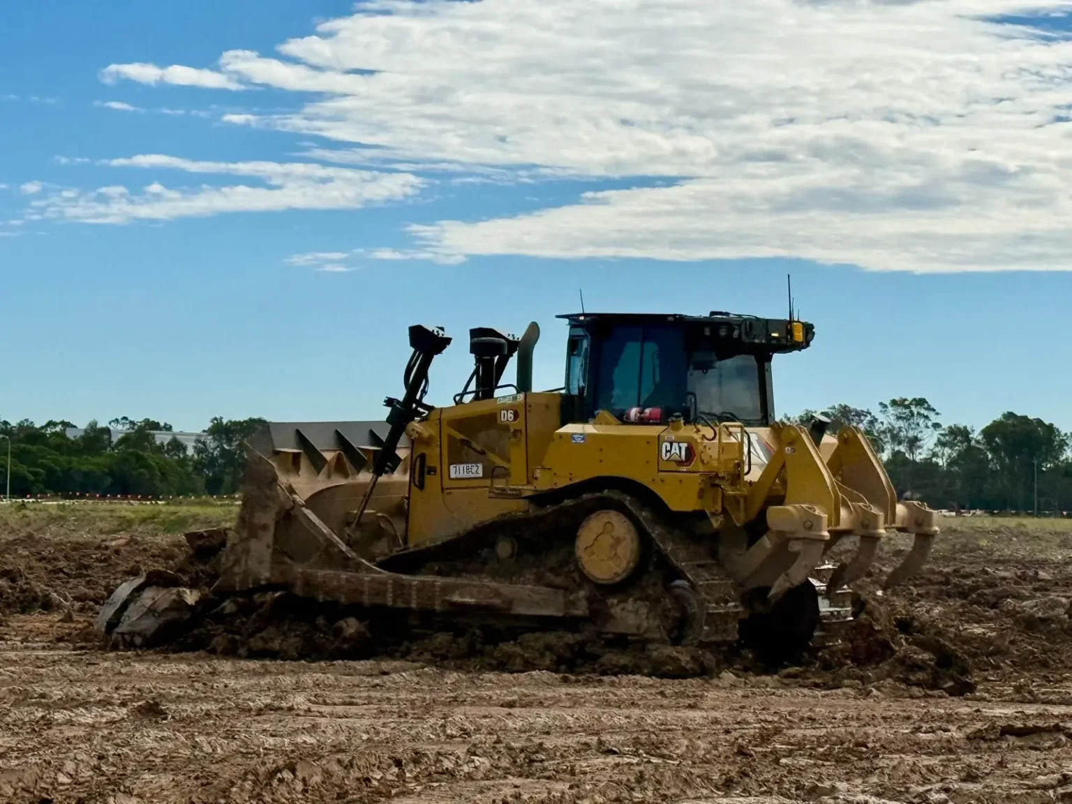 Yellow bulldozer working on a dirt site under a blue sky, ACE Rental dozer hire in action.